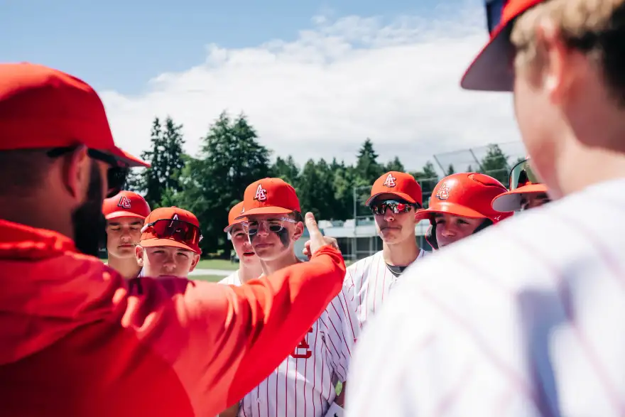 A team gathered in a huddle around the coach at a game in British Columbia.