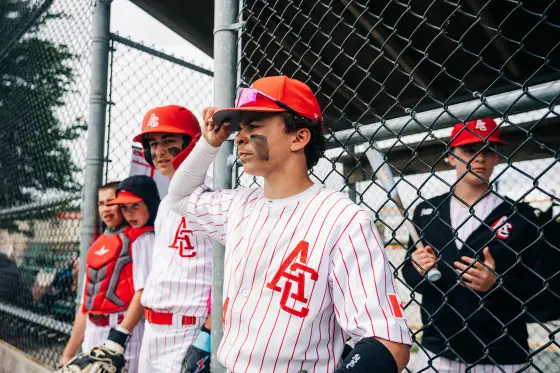 Young Cardinals players line up along the chain link fence during a session.