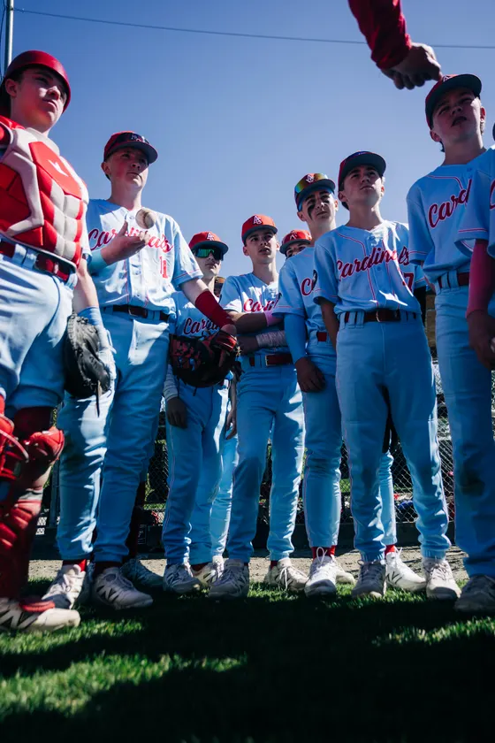 Cardinals players put their hands in for a team huddle.
