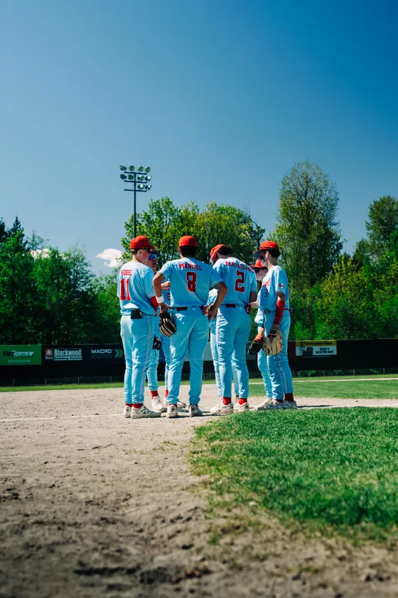 Abbotsford Cardinals infielders gather on the mound during a game.