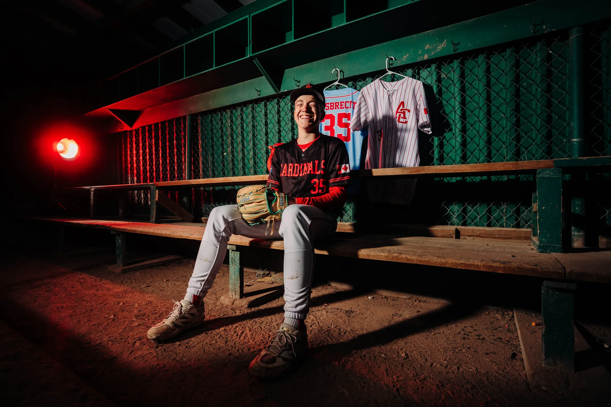 The Cardinals dugout after dark, benches empty, one red light burning