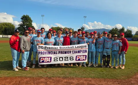 The Cardinals players and coaches gathered on the field, holding the BC Premier Baseball League's Provincial Premier Champion 2026 banner.
