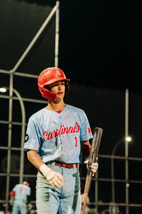An Abbotsford Cardinals hitter waits on deck under the lights.