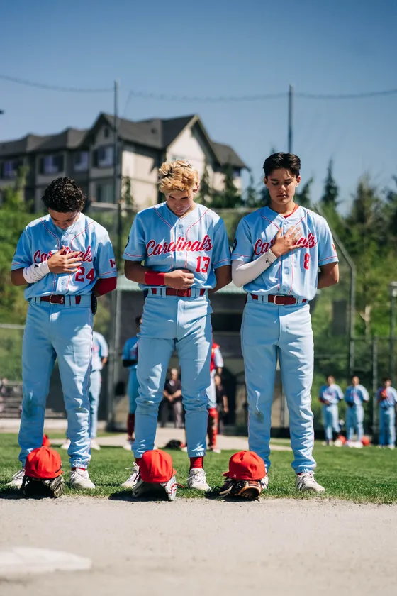 Abbotsford Cardinals players stand for the anthem before a game.
