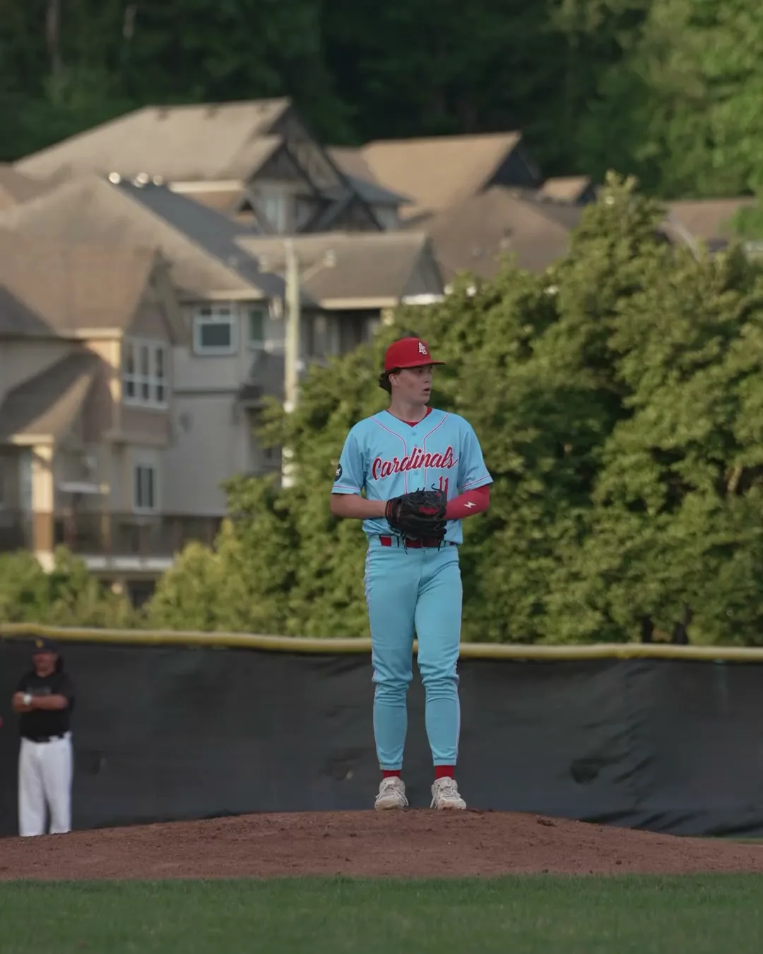 An Abbotsford Cardinals pitcher sets on the mound in the evening light